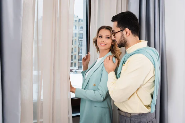 Femme souriante regardant petit ami musulman près de la fenêtre de l'hôtel — Photo de stock