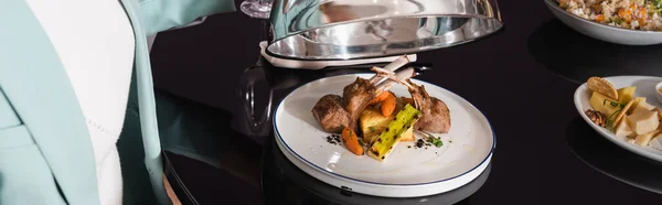 Vista recortada de la mujer cerca de deliciosa cena con carne en la habitación del hotel, pancarta - foto de stock