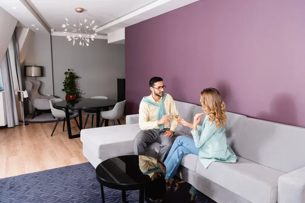 Araber hält Glas Wein neben Freundin auf Couch im Hotel — Stockfoto