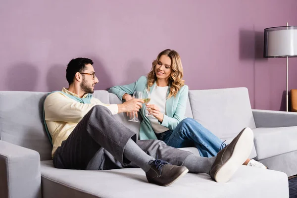 Smiling woman clinking wine with muslim boyfriend in hotel — Stock Photo