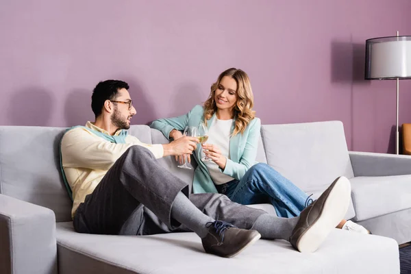 Mujer sonriente tintineo de vino con novio musulmán en el hotel - foto de stock