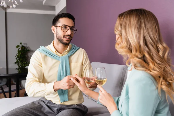 Muslim man with glass of wine holding hand of girlfriend in hotel room — Stock Photo