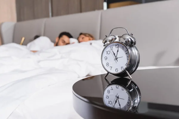 Réveil près du couple endormi sur fond flou à l'hôtel — Photo de stock
