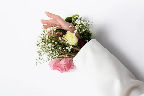 Vista recortada de la mano femenina con diferentes flores en manga sobre fondo gris - foto de stock