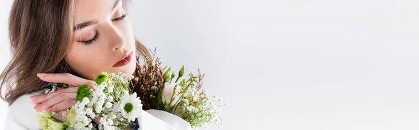 Молода брюнетка позує з квітами ізольована на сірому, банер — стокове фото