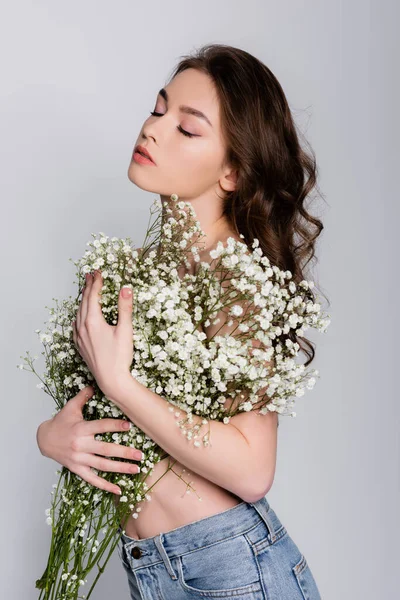 Shirtless model holding flowers near chest isolated on grey — Stock Photo