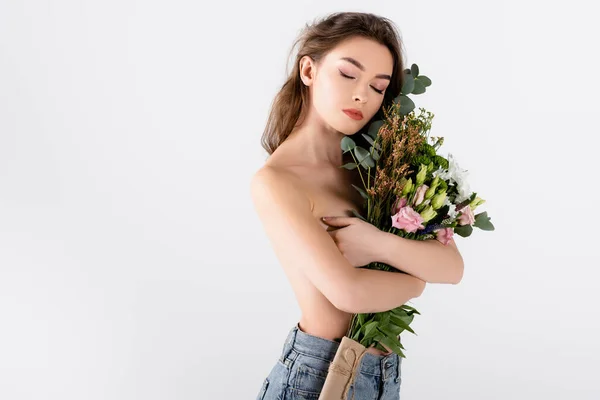 Shirtlose und brünette Frau mit Blumen in Brustnähe isoliert auf grau — Stockfoto