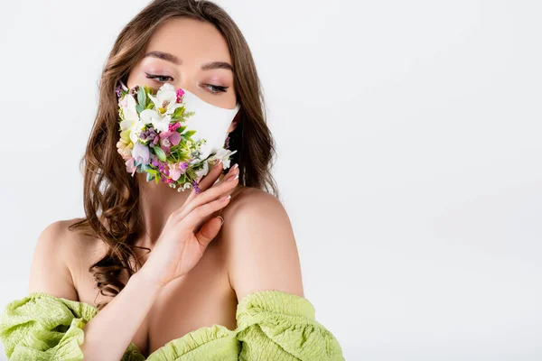 Jeune femme en chemisier aux épaules nues et masque médical aux fleurs isolées sur gris avec espace de copie — Photo de stock