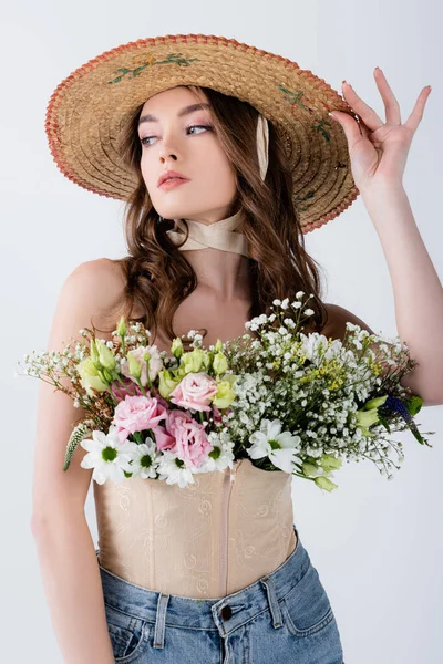 Mujer con estilo en sombrero de sol y flores en blusa aislada en gris - foto de stock