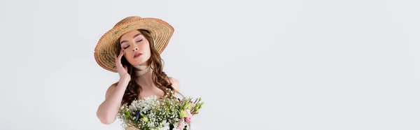 Donna in cappello di paglia in piedi con gli occhi chiusi vicino a fiori isolati su grigio, striscione — Foto stock