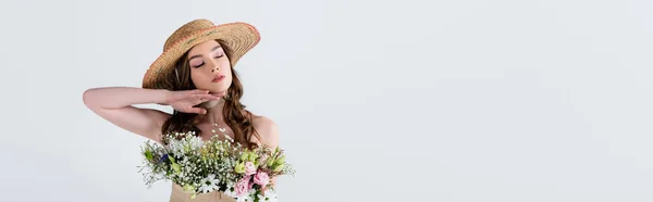 Giovane donna in elegante cappello di paglia con fiori in camicetta in piedi con gli occhi chiusi isolati su grigio, banner — Foto stock