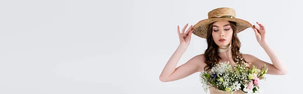 Model holding sun hat while hosing with flowers in blouse isolated on grey, banner — Stock Photo
