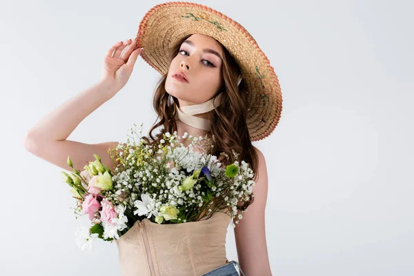 Modèle à la mode posant avec des fleurs en chemisier isolé sur gris — Photo de stock