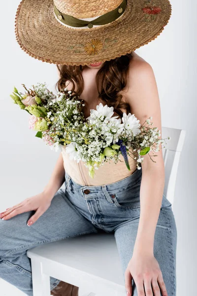 Strohhut bedeckt Gesicht der Frau mit Blumen in Bluse isoliert auf grau — Stockfoto