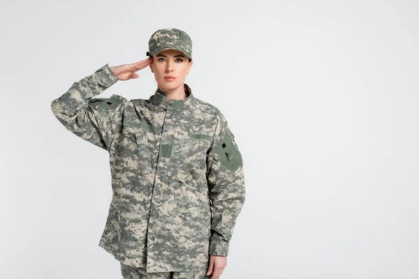 Soldier in uniform saluting at camera isolated on grey — Stock Photo