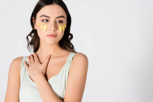 Giovane donna bruna con petali gialli sul viso isolato su bianco — Foto stock