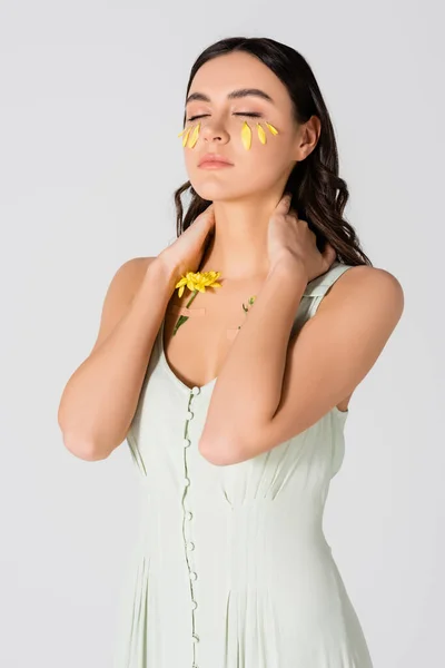 Brunette woman with petals on face and plasters with yellow flowers on body isolated on white — Stock Photo