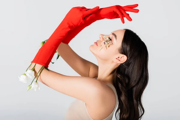 Seitenansicht der sinnlichen Frau in roten Handschuhen mit Blumen isoliert auf weiß — Stockfoto