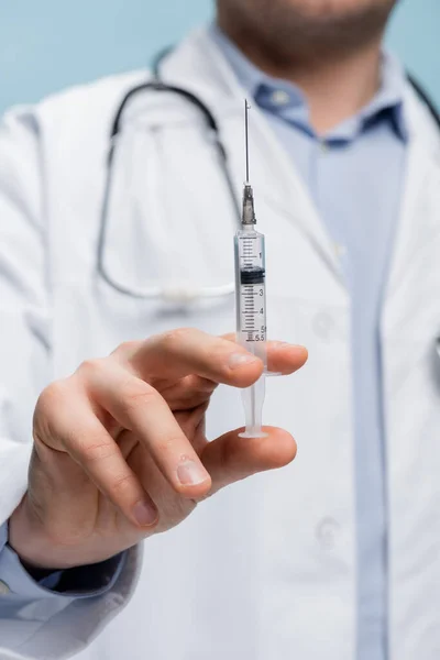 Partial view of doctor holding syringe isolated on blue — Stock Photo