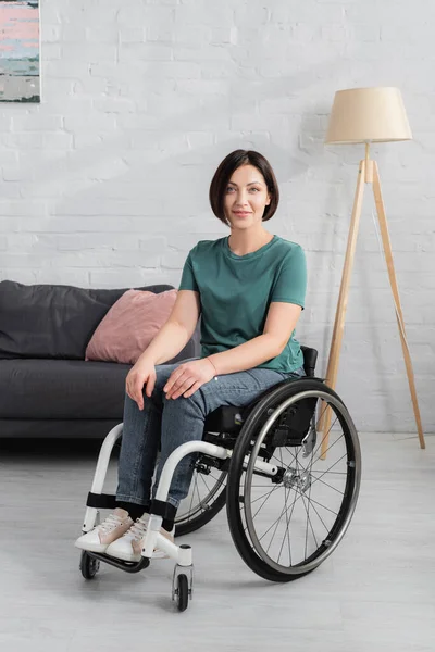 Disabled woman in wheelchair smiling at camera — Stock Photo
