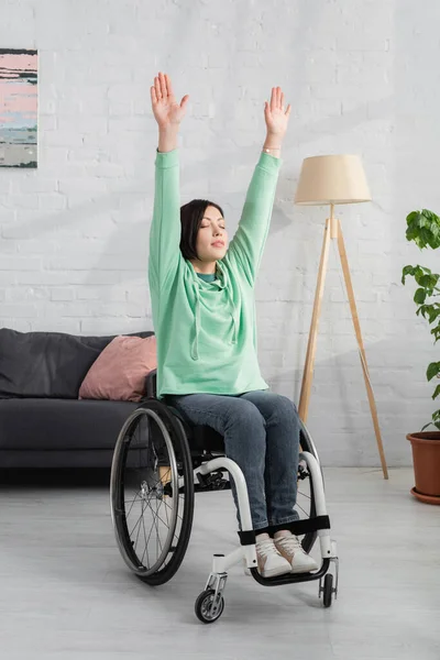 Behinderte Frau trainiert im Rollstuhl im Wohnzimmer — Stockfoto