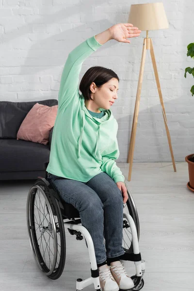 Женщина в инвалидной коляске работает дома — стоковое фото