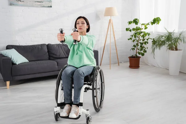 Unzufriedene Frau hält Hanteln beim Training zu Hause — Stockfoto