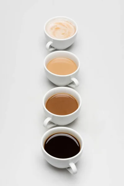 Different freshy made coffee drinks with milk on white — Stock Photo