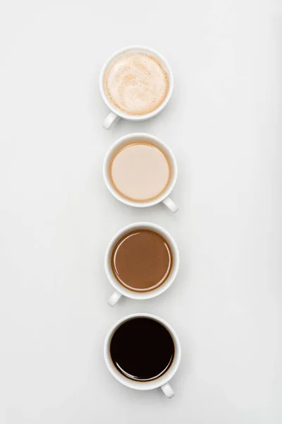 Top view of different freshy made coffee drinks with milk on white — Stock Photo