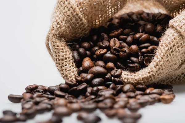 Bolsa de saco hessiano con granos de café tostados borrosas aislados en blanco — Stock Photo