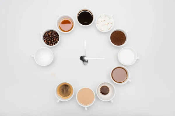 Вид зверху чорно-молочна кава в чашках поблизу бобів і цукрових кубиків на білому — стокове фото