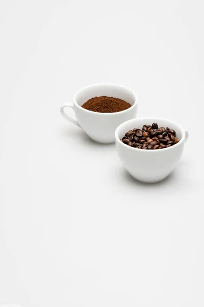 Квасоля і мелена кава в чашках на білому — стокове фото