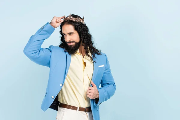 Bärtiger hispanischer Mann lächelt und trägt Krone isoliert auf blauem Grund — Stockfoto