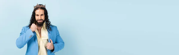 Homem hispânico barbudo na coroa ajustando jaqueta em azul, banner — Fotografia de Stock