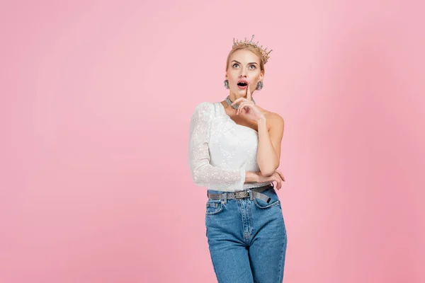 Mujer rubia sorprendida en la corona de lujo de pie aislado en rosa — Stock Photo