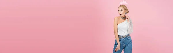 Mujer asombrada y elegante sosteniendo la corona de papel en palo aislado en rosa, bandera — Stock Photo