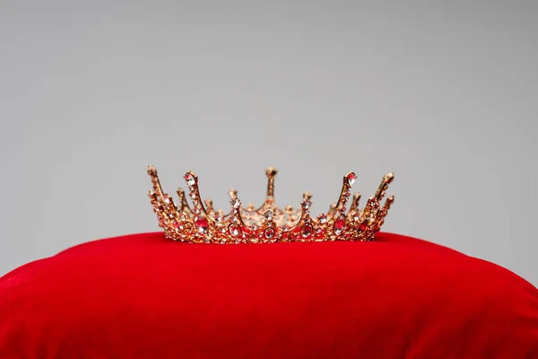 Luxo coroa real na almofada de veludo vermelho isolado em cinza — Fotografia de Stock