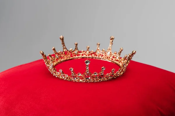Coroa de luxo na almofada de veludo vermelho isolado em cinza — Fotografia de Stock