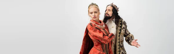 Rey y reina interracial en ropa medieval y coronas aisladas en blanco, bandera - foto de stock