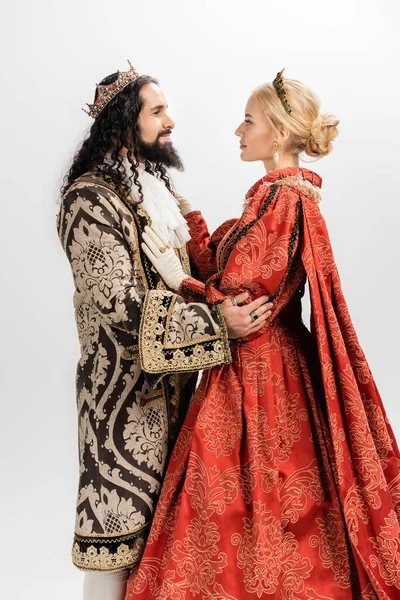 Interracial king and queen in medieval clothing and crowns hugging isolated on white — Stock Photo