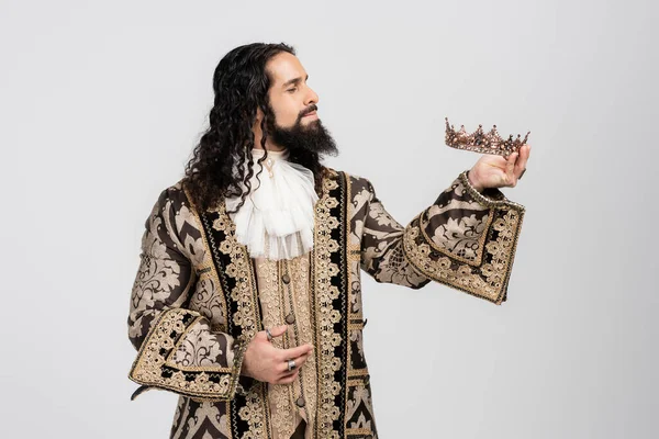 Hispanic king in medieval clothing holding golden crown isolated on white — Stock Photo