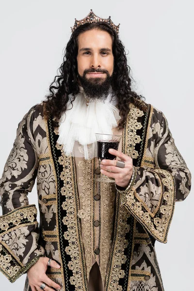 Hispanic king in medieval clothing and golden crown holding glass of red wine isolated on white — Stock Photo