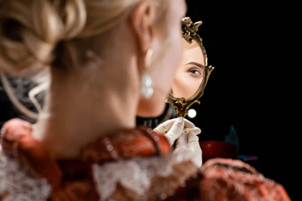Blonde queen looking at mirror isolated on black — Stock Photo