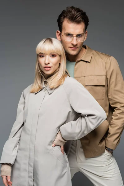 Jóvenes modelos de moda posando de pie juntos aislados en gris - foto de stock