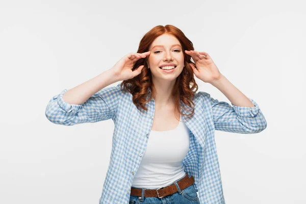 Joyful redhead young woman in blue checkered shirt looking at camera isolated on white — Stock Photo