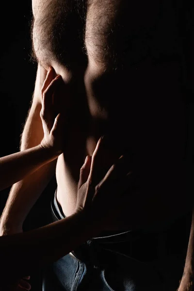 Обрізаний вид жінки, що торкається сексуального тіла на без сорочки хлопець ізольований на чорному — стокове фото