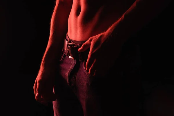 Iluminação vermelha no corpo muscular do homem sexy isolado no preto — Fotografia de Stock