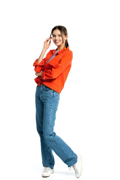 Pleine longueur de gaie jeune femme en chemise orange debout isolé sur blanc — Photo de stock