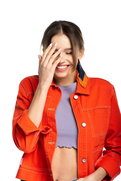 Glückliche junge Frau in bauchfreiem Top und orangefarbenem Hemd, die isoliert auf Weiß lächelt — Stockfoto