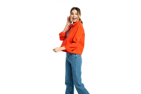 Изумленная молодая женщина в джинсах, топ и оранжевая рубашка изолированы на белом — стоковое фото